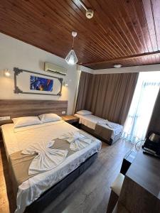 1 dormitorio con 2 camas y techo de madera en Kutberk Hotel Kemer, en Kemer