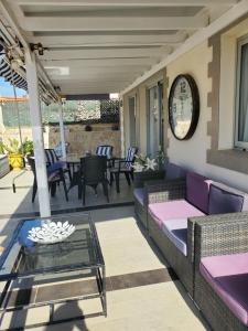 een patio met banken, een tafel en een klok bij Villa Sunrise with heated pool. in Callao Salvaje