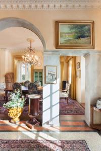 een woonkamer met een kroonluchter en een eetkamer bij Villa Lidia-Dimora storica a Caprino Veronese in Caprino Veronese