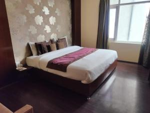 duże łóżko w pokoju z oknem w obiekcie Hotel Green Leaf , Srinagar w mieście Śrinagar