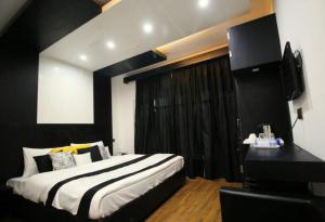 um quarto com uma cama em preto e branco e uma secretária em Hotel Green Leaf , Srinagar em Srinagar