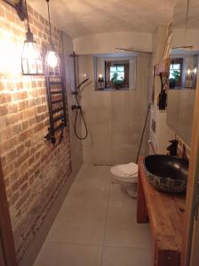 La salle de bains est pourvue d'un lavabo et d'un mur en briques. dans l'établissement Klimatyczne studio z parkingiem, à Katowice