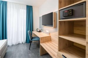 a hotel room with a desk and a tv at Best Western Hotel Lippstadt in Lippstadt