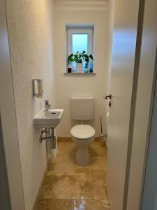 a bathroom with a toilet and a sink and a window at Ferienhaus Federico nahe Legoland in Burgau