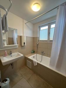 a bathroom with a tub and a sink and a mirror at Ferienhaus Federico nahe Legoland in Burgau