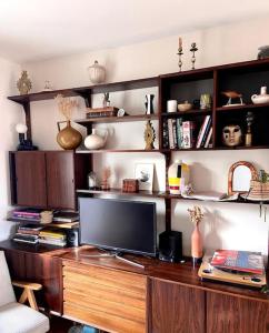 a wooden desk with a television on top of it at Appartement familial, vue canal Ourcq, parking in Pantin