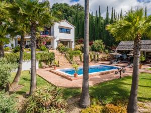 ein Haus mit einem Pool und Palmen in der Unterkunft Luxury country house with pool and breathtaking views in Casares