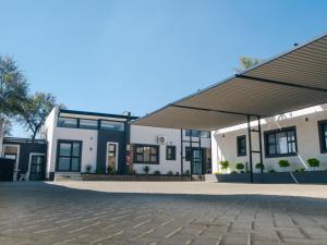a large white building with a roof at The Lofts Prestige Suites in Windhoek