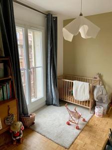 a baby room with a crib and a window at Appartement familial, vue canal Ourcq, parking in Pantin