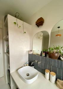 a bathroom with a white sink and two mirrors at Appartement familial, vue canal Ourcq, parking in Pantin