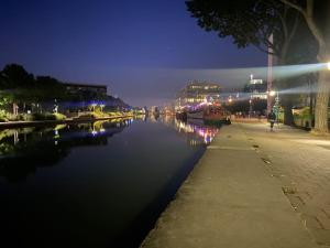 a view of a river at night at Appartement familial, vue canal Ourcq, parking in Pantin