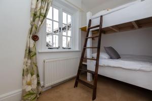 a bunk bed with a ladder in a room at Beautifully Renovated Old Sweet Shop in Youlgreave