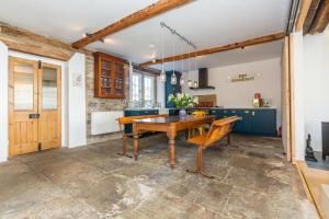 a dining room with a wooden table and a kitchen at Beautifully Renovated Old Sweet Shop in Youlgreave