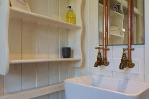 a white bathroom with a sink and a mirror at Beautifully Renovated Old Sweet Shop in Youlgreave +15 photos
