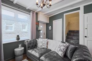 Host & Stay - Thorne Cottage في ستانهوب: غرفة معيشة مع أريكة جلدية وثريا
