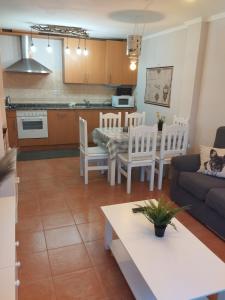 a kitchen and living room with a table and a couch at karluchi a Mariña 2 Barreiros in Barreiros