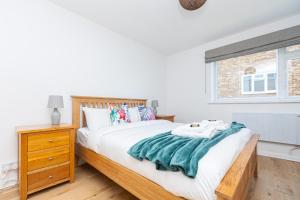 a bedroom with a large bed and a window at Lit & airy 2BR Flat wparking & balcony, Wimbledon in London