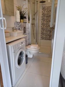 a bathroom with a washing machine and a toilet at Urocze Studio 7 z parkingiem in Katowice