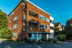 a red brick building with white windows at Lit & airy 2BR Flat wparking & balcony, Wimbledon in London