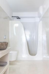 baño blanco con bañera y aseo en CSKY VILLAS, en Imerovigli