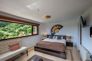 ein Schlafzimmer mit einem Bett und einem großen Fenster in der Unterkunft Luxury country house with pool and breathtaking views in Casares