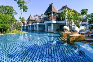 a swimming pool in front of a villa at Avani Plus Koh Lanta Krabi Resort in Ko Lanta