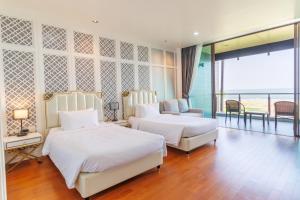 um quarto de hotel com duas camas e uma varanda em Sea Sand Sun Hua Hin Resort em Phetchaburi