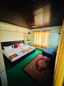 - une chambre avec un grand lit et un sol vert dans l'établissement Thoppil Homestay Munnar, à Munnar