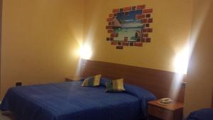 a bedroom with a blue bed and a painting on the wall at Hotel Residence Memmina in Frosinone