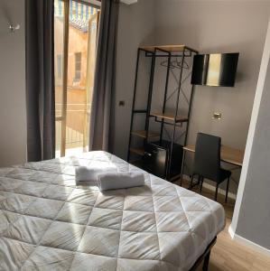 a bedroom with a bed and a desk and a window at Riva Reno 4 Rooms in Bologna