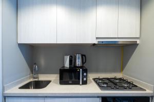 uma cozinha com um lavatório, um micro-ondas e um fogão em Business Bay - Near Metro Station - 1 Bedroom Apartment - Zada Tower - Keyrock HH em Dubai