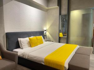 ein Schlafzimmer mit einem großen Bett mit gelben Kissen in der Unterkunft Studio Service Apartment 2guests allows stay up to 5guests 19055 in Manila