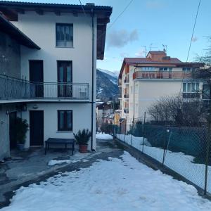 una strada con neve di fronte a un edificio di Alloggio Grande Joséphine a Oulx