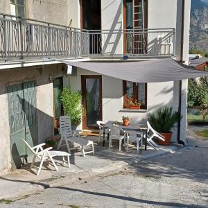 een patio met een tafel en stoelen en een parasol bij Alloggio Grande Joséphine in Oulx