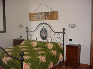 アッシジにあるAgriturismo La Cantina San Martinoのベッドルーム1室(花の緑の毛布付きベッド1台付)