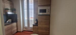 a small kitchen with a microwave and a window at Le Perchoir de Cassis Cocoon in Cassis +46 photos