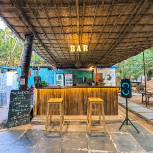 bar z dwoma stołkami i znak, który czyta bar w obiekcie Traverse Luxe Hostel Palolem w mieście Palolem
