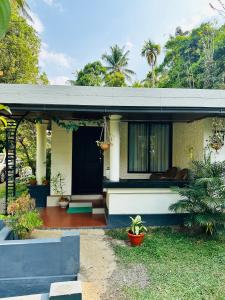 a house with a front porch with a porch at Thoppil Homestay Munnar in Munnar