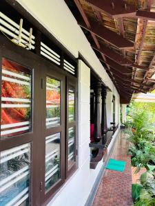 ganek domu z oknami i roślinami w obiekcie Thoppil Homestay Munnar w mieście Munnar
