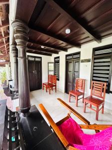 ein Wohnzimmer mit Stühlen und einer Couch auf dem Boden in der Unterkunft Thoppil Homestay Munnar in Munnar
