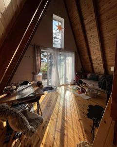 a living room with a wooden floor and a large window at WoodMood in Žabljak