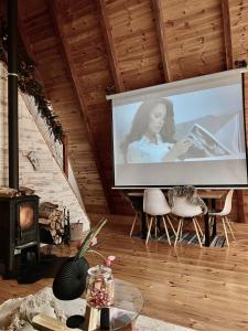 uma televisão de ecrã grande numa sala de estar com uma mulher em WoodMood em Žabljak