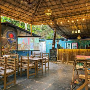 a restaurant with a bar with tables and chairs at Traverse Luxe Hostel Palolem in Palolem