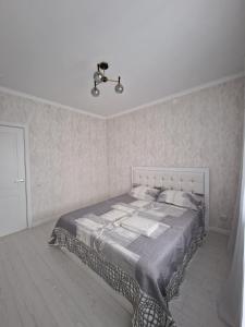 a bedroom with a bed and a chandelier at Jetysu2 in Prigorodnyy