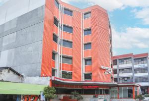 Townhouse Oak J&b Gunung Sahari في جاكرتا: مبنى احمر طويل مع برتقال