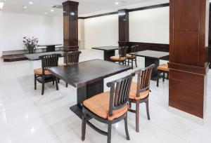 uma sala de jantar com mesas e cadeiras pretas em Townhouse Oak J&b Gunung Sahari em Jakarta