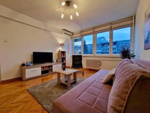 uma sala de estar com um sofá e uma televisão de ecrã plano em Dino apartment em Sarajevo