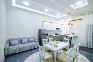 a kitchen and living room with a table and a couch at Cozy Two-Storey House in Bukhara