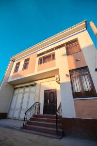 a house with a staircase in front of it at Cozy Two-Storey House in Bukhara