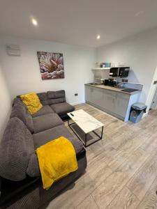 a living room with a couch and a kitchen at Glenariff Forest Evergreen Lodge in Glenariff